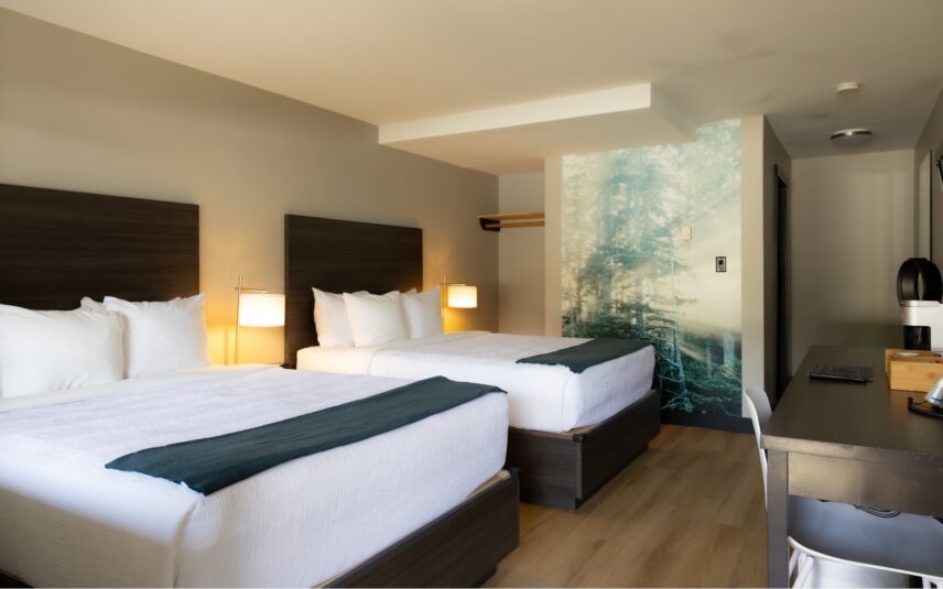 Spacious hotel room with two queen beds and Tofino Resort + Marina forest photography piece