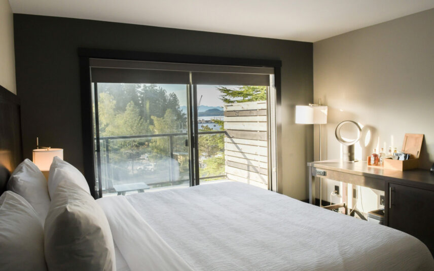 Deluxe room window view of Tofino’s harbour and surrounding rainforest