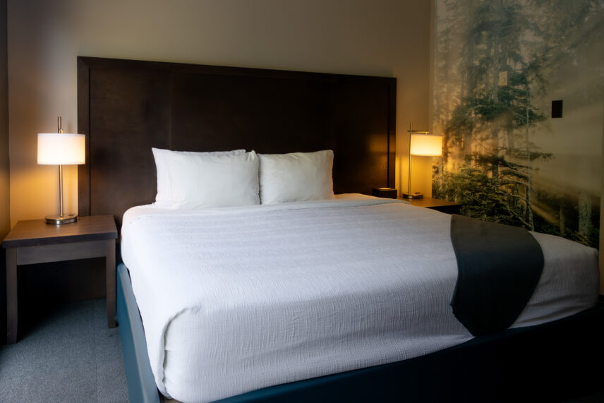 Alternate view of king room with bed and large ocean artwork