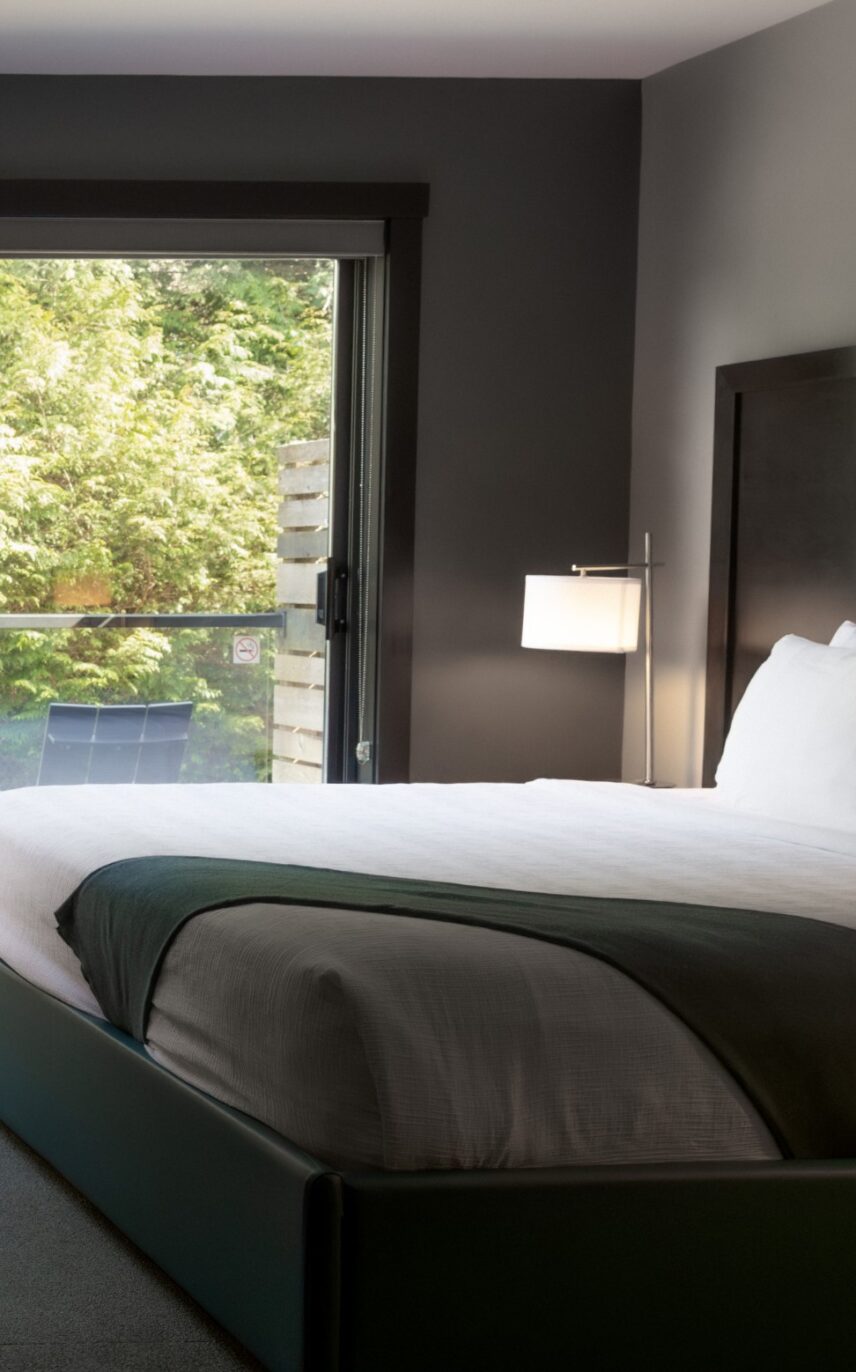 King bed in cozy room with ocean-inspired artwork above the headboard