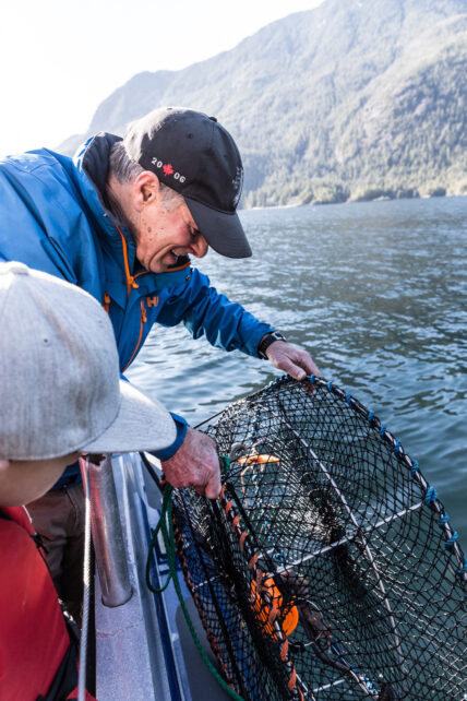 Guests pulling up a Dungeness crab trap during a guided fishing and crabbing adventure in Tofino