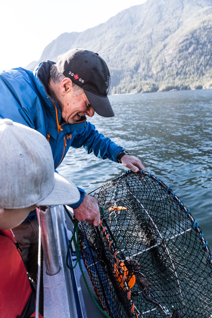 Guests pulling up a Dungeness crab trap during a guided fishing and crabbing adventure in Tofino