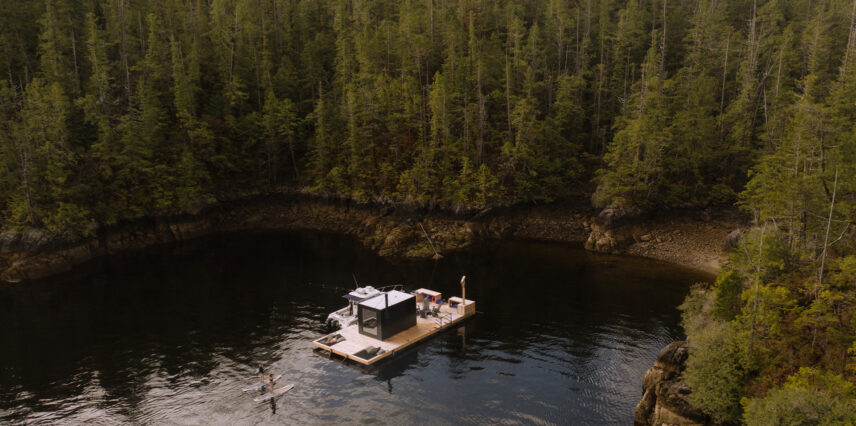 Drone view of the floating sauna at Tofino Resort + Marina with guests paddleboarding around the dockv
