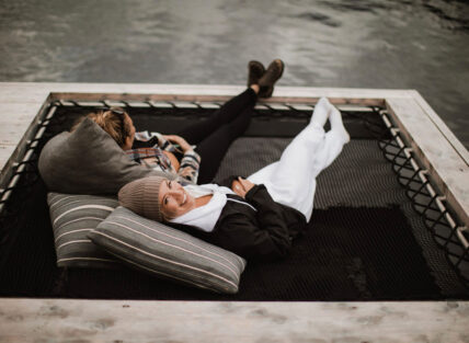 Two women relaxing in cozy hammocks at the floating sauna dock in Tofino