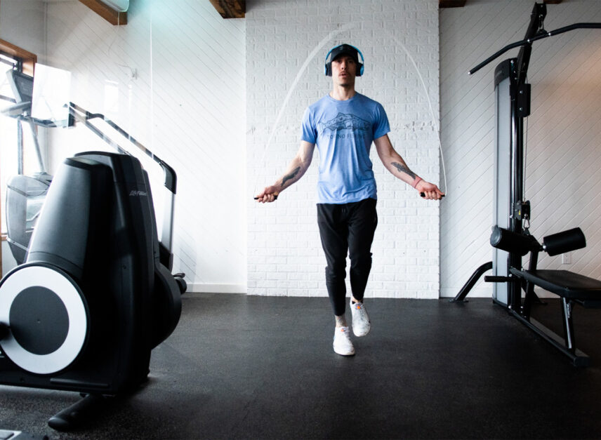 Man skipping rope in a gym with natural lighting
