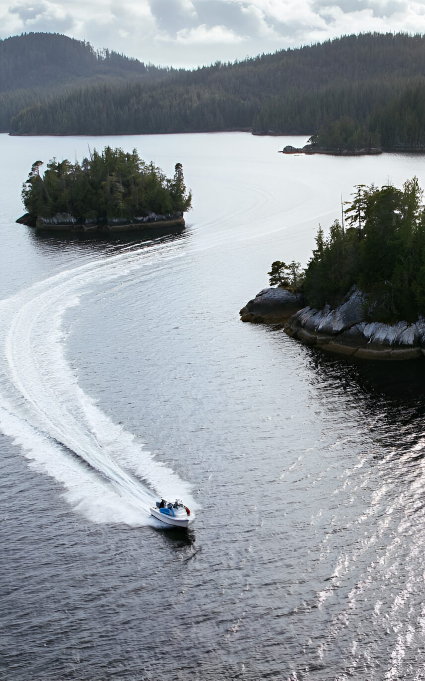 Aerial view of a boat navigating the serene waters of Clayoquot Sound in Tofino
