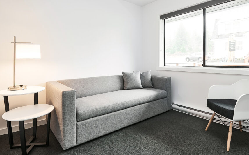 Pull-out couch in queen suite’s living space with soft-toned decor