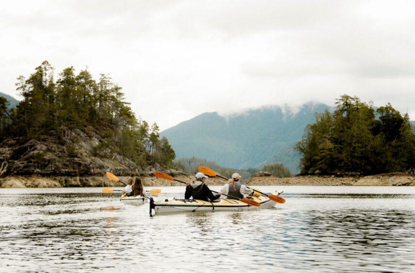 Distant view of two kayakers gliding through the peaceful waters of Clayoquot Sound