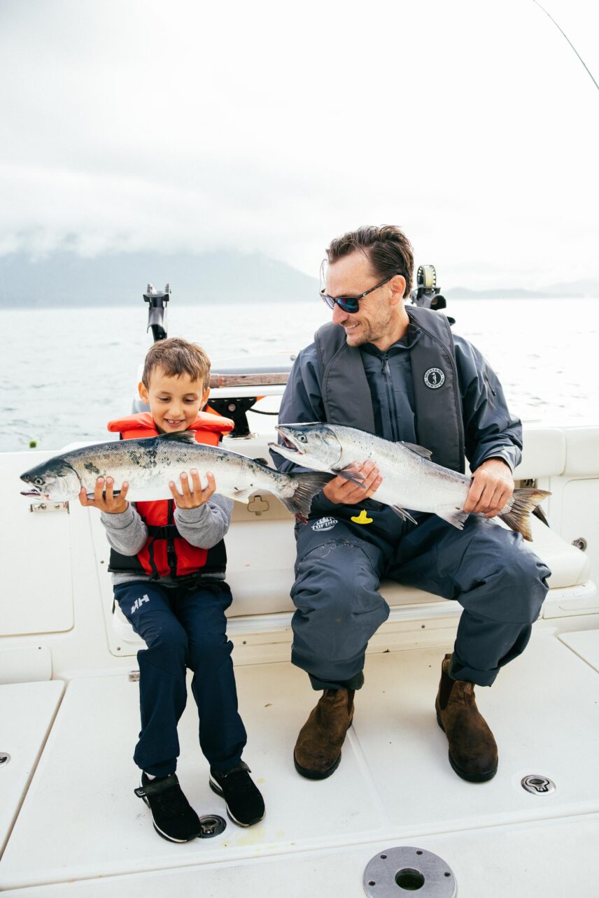 A father and son beam with pride as they each show off their freshly caught fish