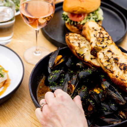 A dish of delicious mussels and garlic bread with vibrant seasoning at one of Tofino's best restaurants