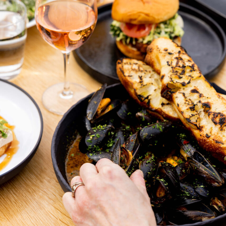 A dish of delicious mussels and garlic bread with vibrant seasoning at one of Tofino's best restaurants