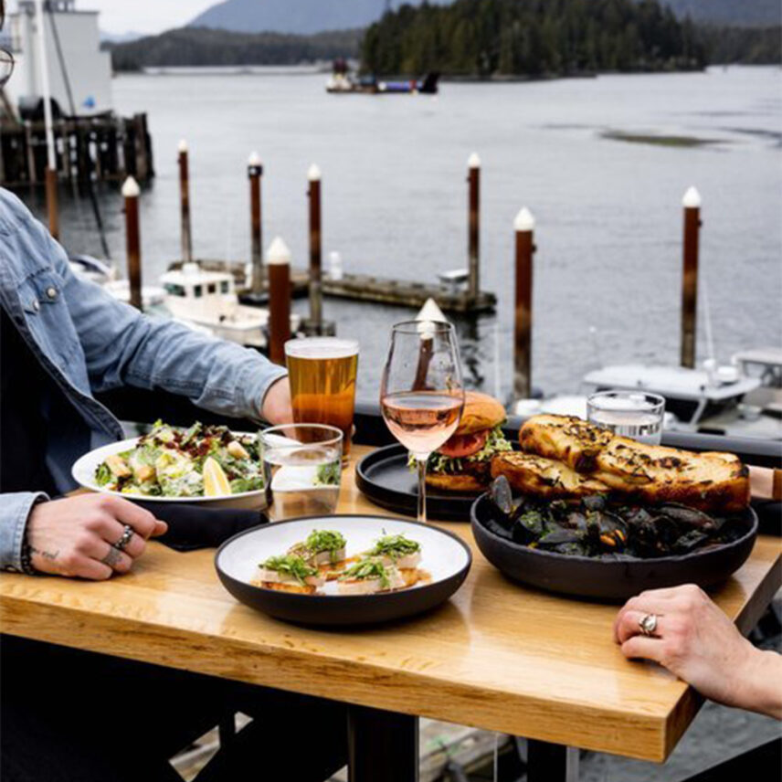 Guests enjoying a meal by the window overlooking the marina