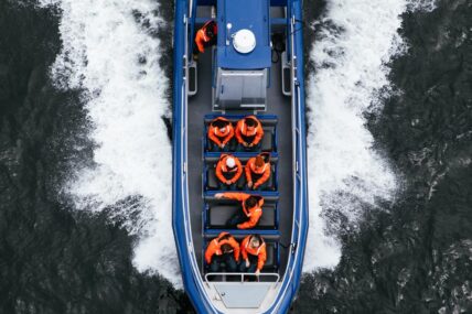 Bird's-eye view of a zodiac with people aboard, cruising the waters of Clayoquot Sound