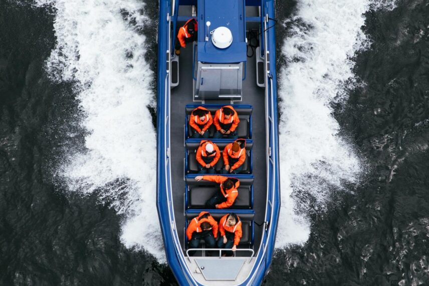 Bird's-eye view of a zodiac with people aboard, cruising the waters of Clayoquot Sound