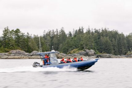 Tofino Resort + Marina’s open Zodiac with guests cruising through the water