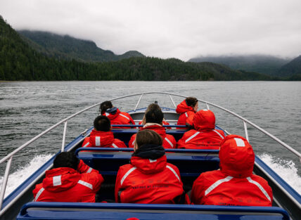 Zodiac boat speeding through Clayoquot Sound with a small group on board