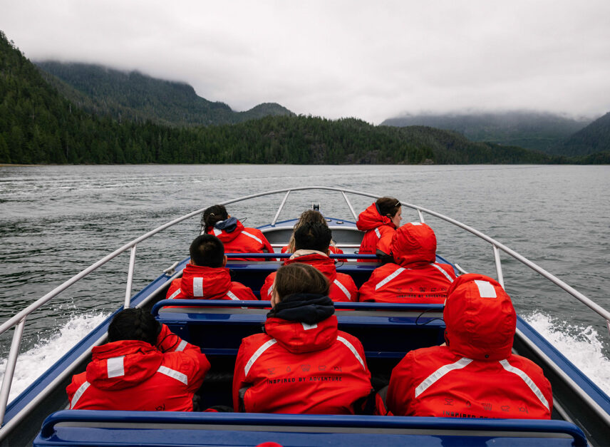 Zodiac boat speeding through Clayoquot Sound with a small group on board