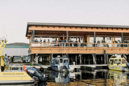 Wedding guests gathered on the dockside at Tofino Resort + Marina’s shore pier with scenic harbour views