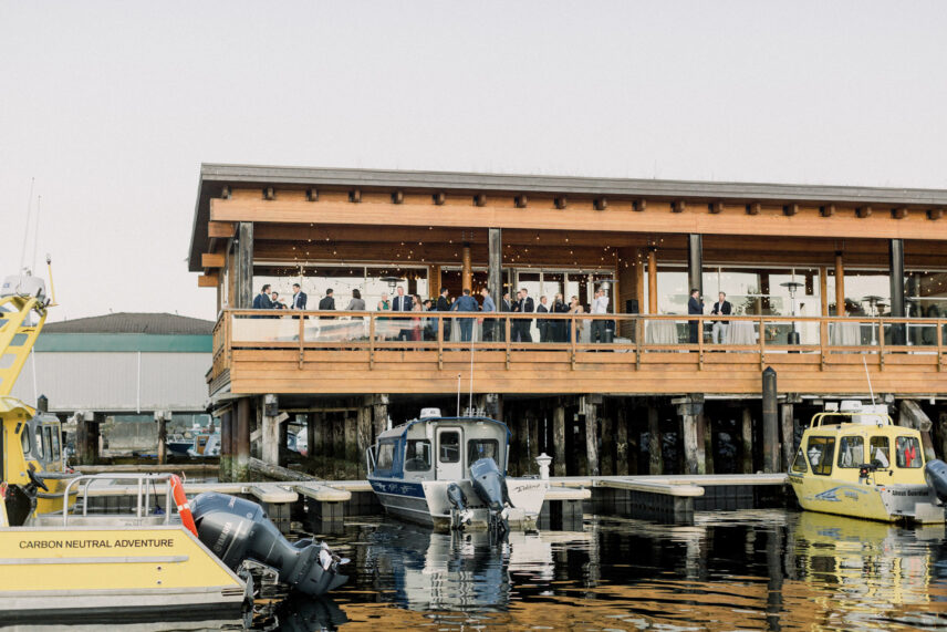 Wedding guests gathered on the dockside at Tofino Resort + Marina’s shore pier with scenic harbour views
