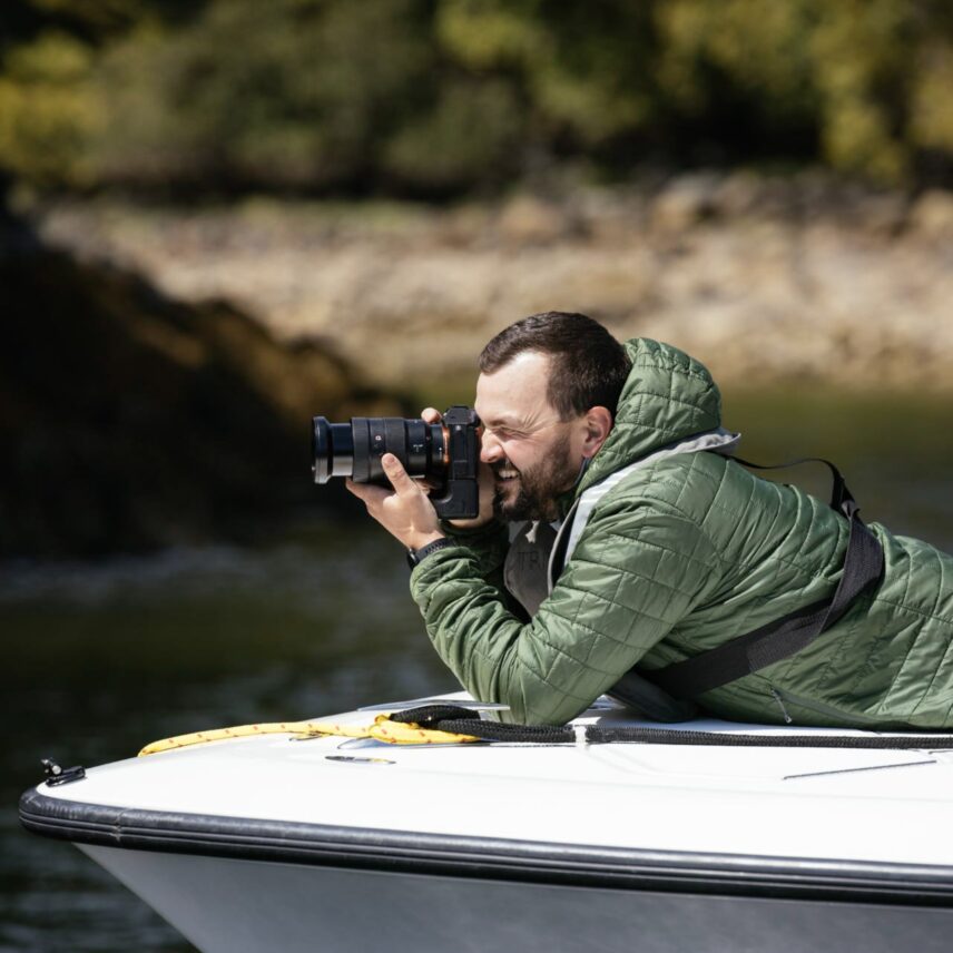 A photographer capturing an image of a bear in the wild