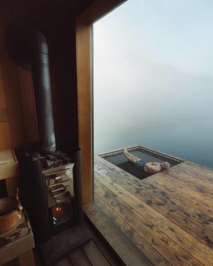 Man relaxing in a hammock surrounded by coastal fog at the floating sauna in Tofino