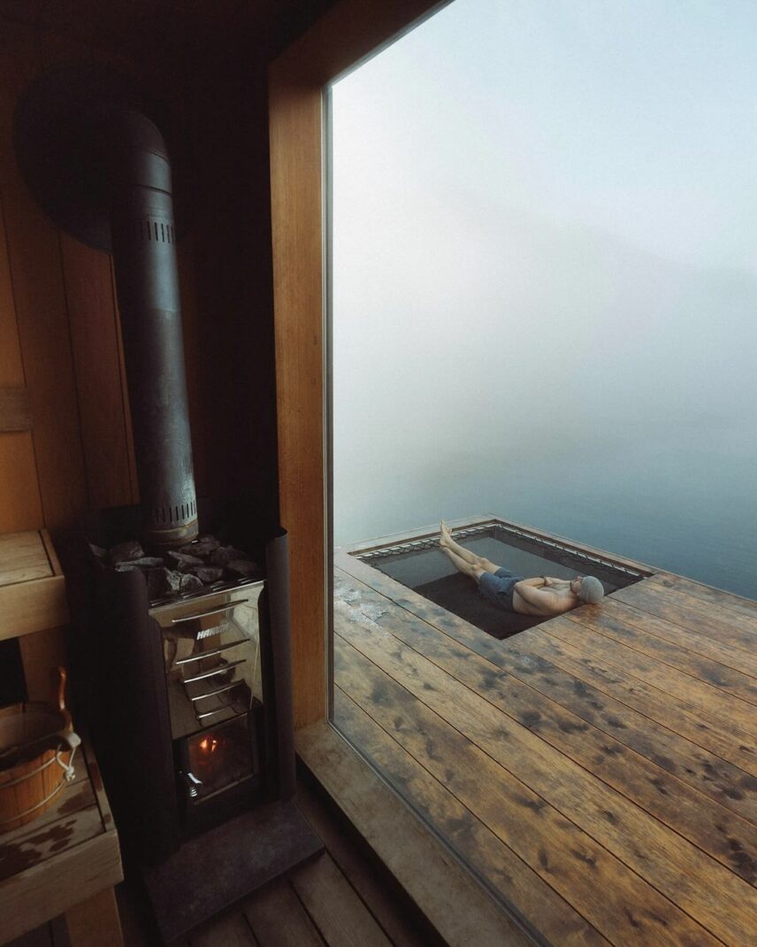 Man relaxing in a hammock surrounded by coastal fog at the floating sauna in Tofino