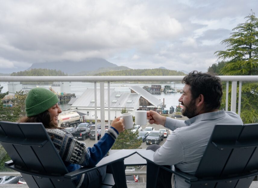 Friends cheering on balcony overlooking the harbour